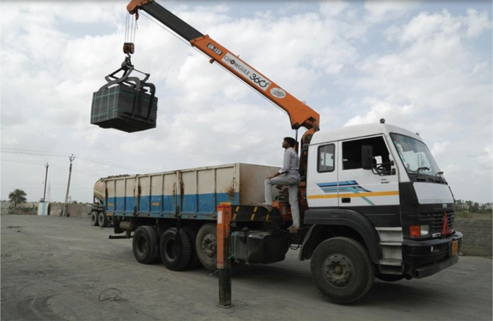 Crane truck unloading construction material